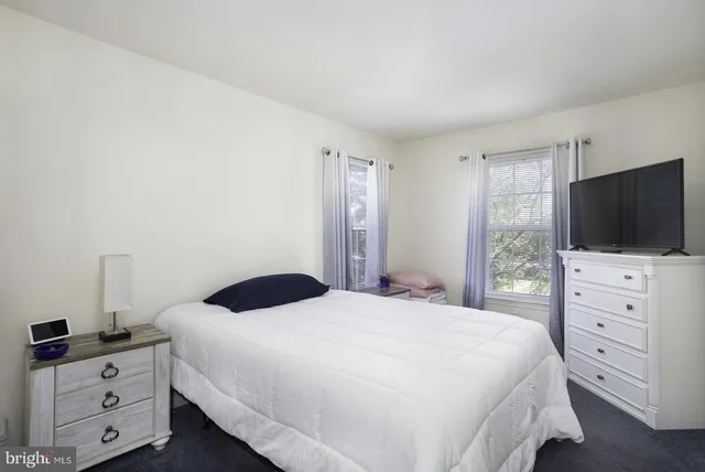 a bedroom with a bed and a flat tv screen in it