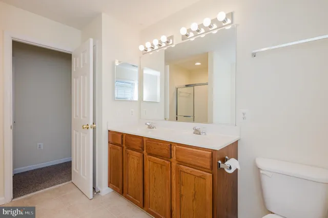 a bathroom with a sink a toilet a mirror and a shower