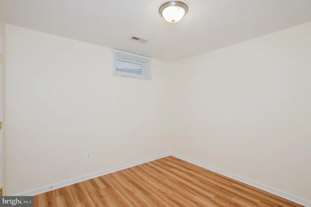 a view of a small space with wooden floor and a window