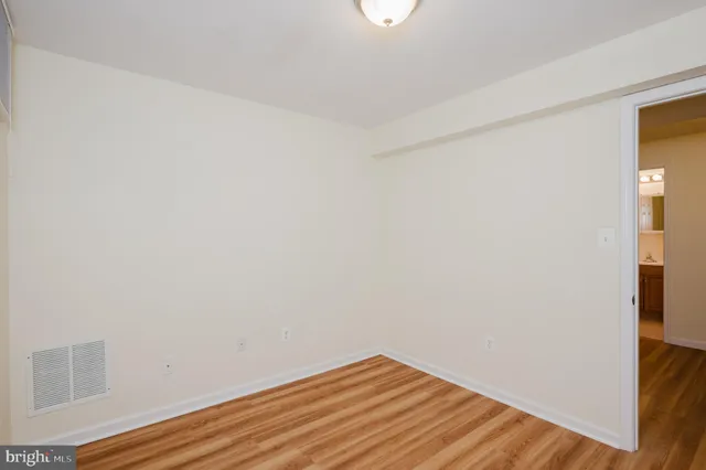 an empty room with wooden floor and closet