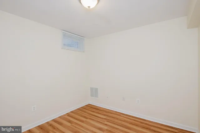 a view of a room with wooden floor and a hallway