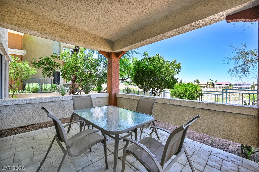 10730 Amber Ridge Drive, Unit 101 Las Vegas, NV 89144 - Photo 26 of 32 An inviting covered patio, ideal for outdoor relaxation, overlooks the desert landscape.