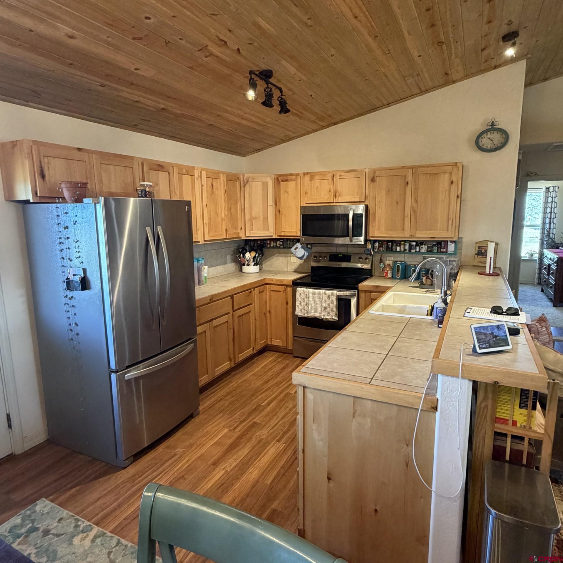 14617 2800th Road Hotchkiss, CO 81419 - Photo 18 of 37 a kitchen with appliances a refrigerator and a stove top oven