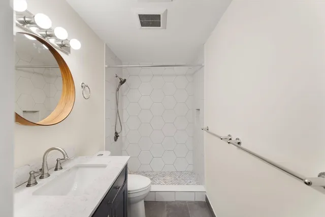 a bathroom with a sink a toilet and shower