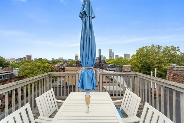 a view of a balcony with wooden chairs