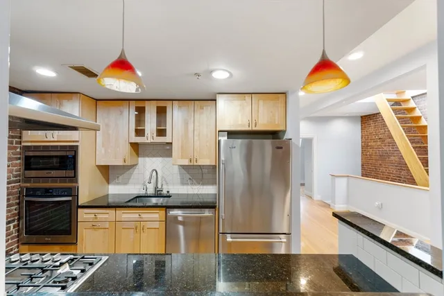 a kitchen with stainless steel appliances granite countertop a refrigerator a stove and a sink