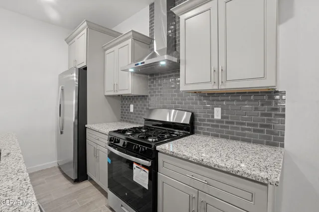 a kitchen with stainless steel appliances granite countertop a sink stove and cabinets