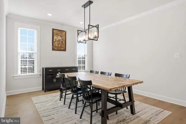 a kitchen with stainless steel appliances kitchen island granite countertop a table chairs and a wooden floor