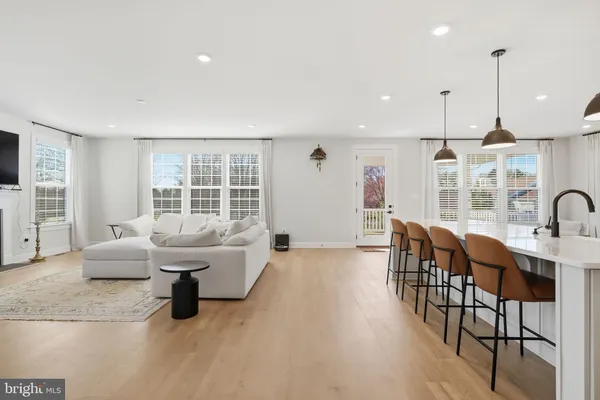 a kitchen with stainless steel appliances kitchen island granite countertop a table chairs and white cabinets