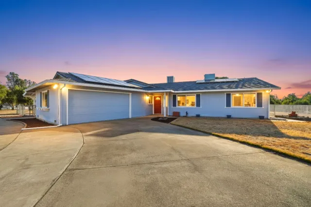 a view of a house with a yard and a garage