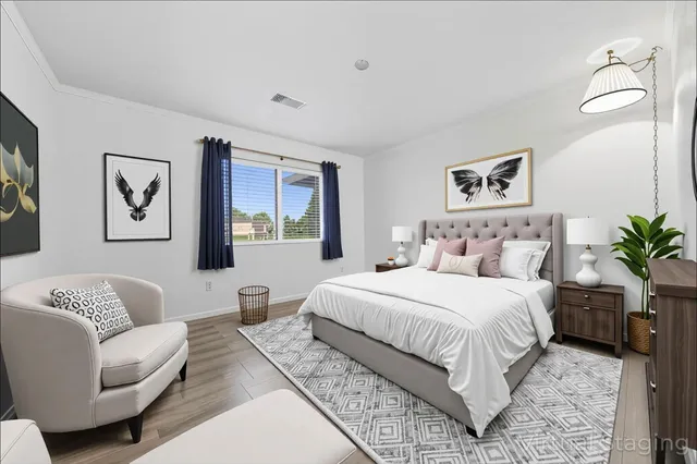 a bedroom with a large bed couch and paintings on the wall