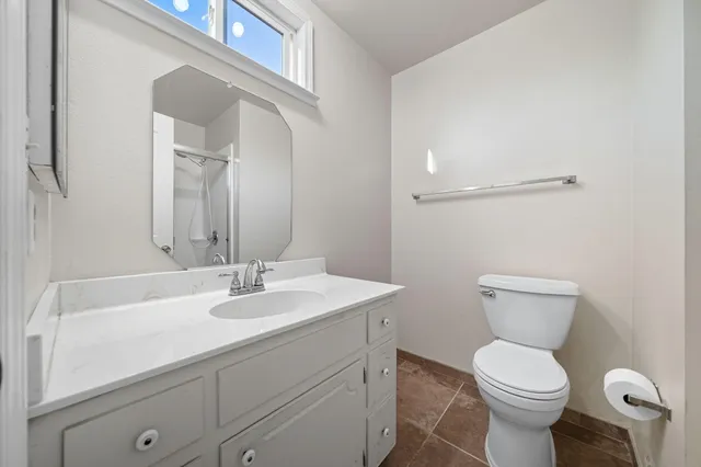 a bathroom with a toilet sink and mirror