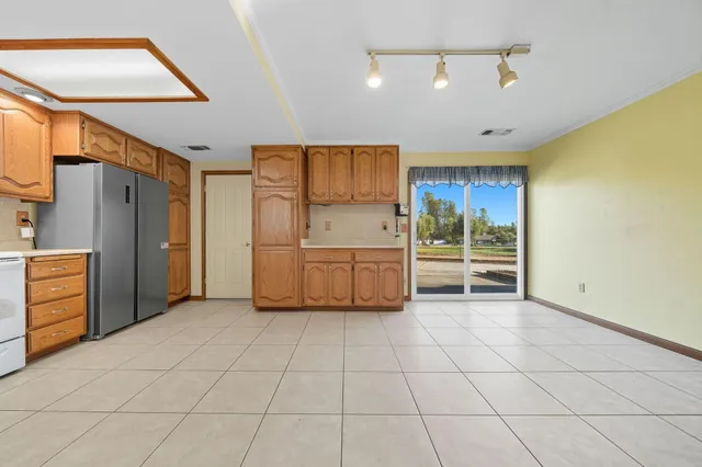 a kitchen with white cabinets and refrigerator