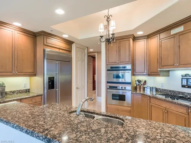 a kitchen with stainless steel appliances granite countertop a refrigerator and a sink