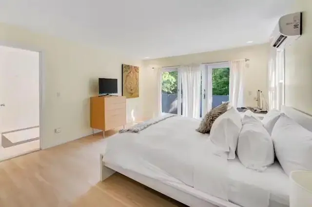 a bedroom with a bed and flat screen tv