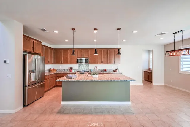 a view of a kitchen with kitchen island stainless steel appliances and a refrigerator