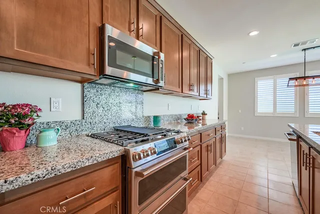 a kitchen with stainless steel appliances granite countertop a stove and cabinets
