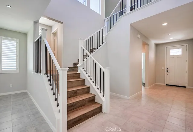 a view of staircase with lots of frames on wall and wooden floor