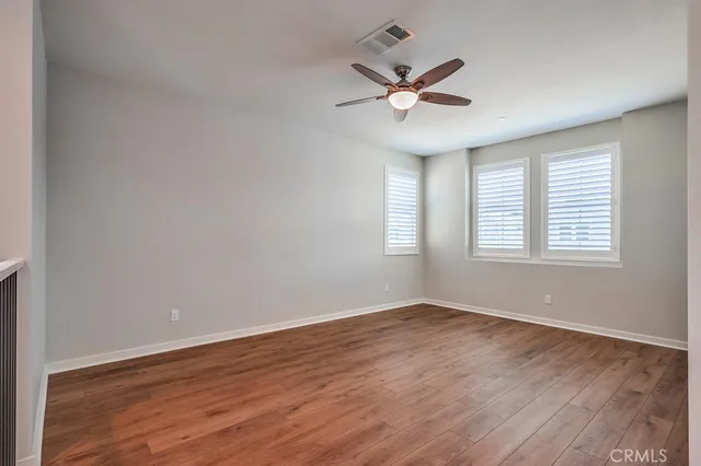a view of a big room with wooden floor and windows