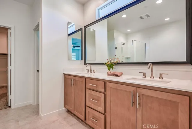 a spacious bathroom with a granite countertop sink mirror and a bathtub