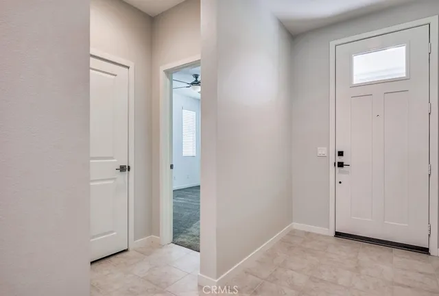 a view of an empty room with closet and mirror