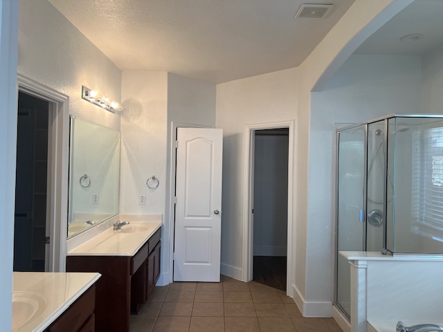 1374 Red Stag Place Round Rock, TX 78665 - Photo 16 of 34 Full bath featuring two vanities, a shower stall, light tile patterned floors, and a garden tub