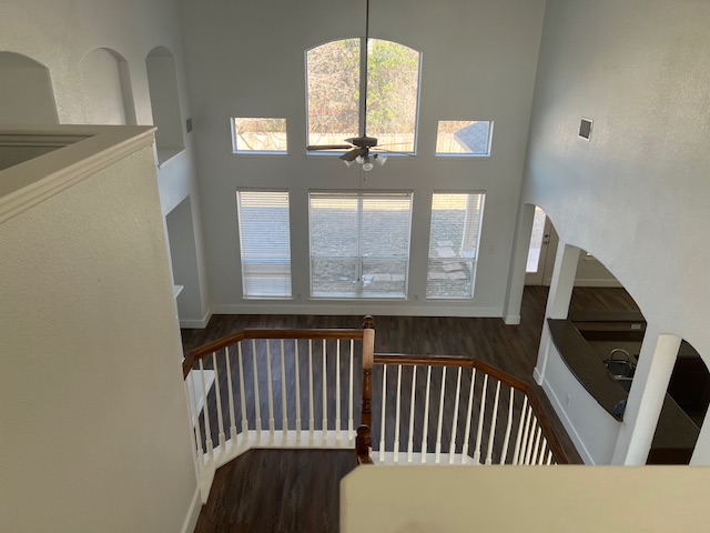 1374 Red Stag Place Round Rock, TX 78665 - Photo 19 of 34 Stairs with a high ceiling, wood finished floors, a ceiling fan, and arched walkways