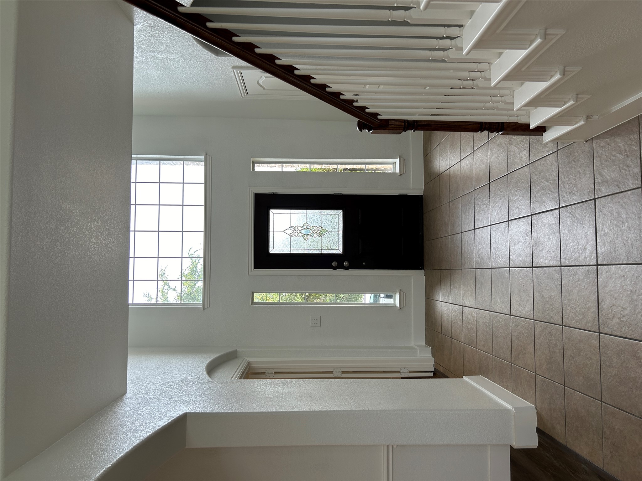 1374 Red Stag Place Round Rock, TX 78665 - Photo 4 of 34 Entryway featuring a high ceiling, a textured wall, plenty of natural light, arched walkways, and light tile patterned floors