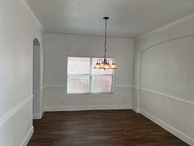 1374 Red Stag Place Round Rock, TX 78665 - Photo 6 of 34 Unfurnished dining area with dark wood finished floors, arched walkways, ornamental molding, and suspended lighting