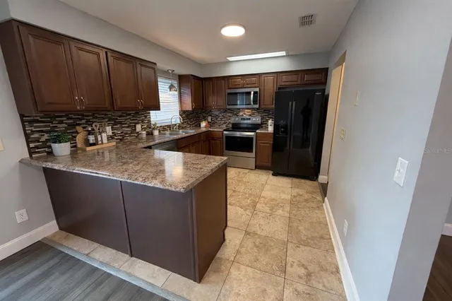 a kitchen with sink a refrigerator and cabinets