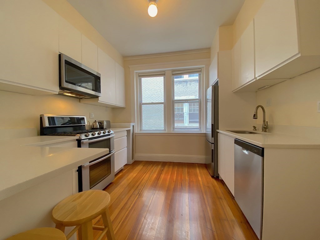91 Bynner Street, Unit 1 Boston, MA 02130 - Photo 19 of 35 a kitchen with stainless steel appliances a stove a sink and a refrigerator