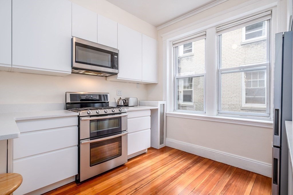 91 Bynner Street, Unit 1 Boston, MA 02130 - Photo 6 of 35 a kitchen with stainless steel appliances a stove microwave and sink
