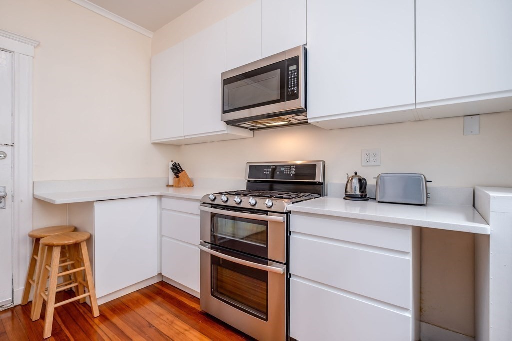91 Bynner Street, Unit 1 Boston, MA 02130 - Photo 7 of 35 a kitchen with stainless steel appliances granite countertop a stove microwave and sink