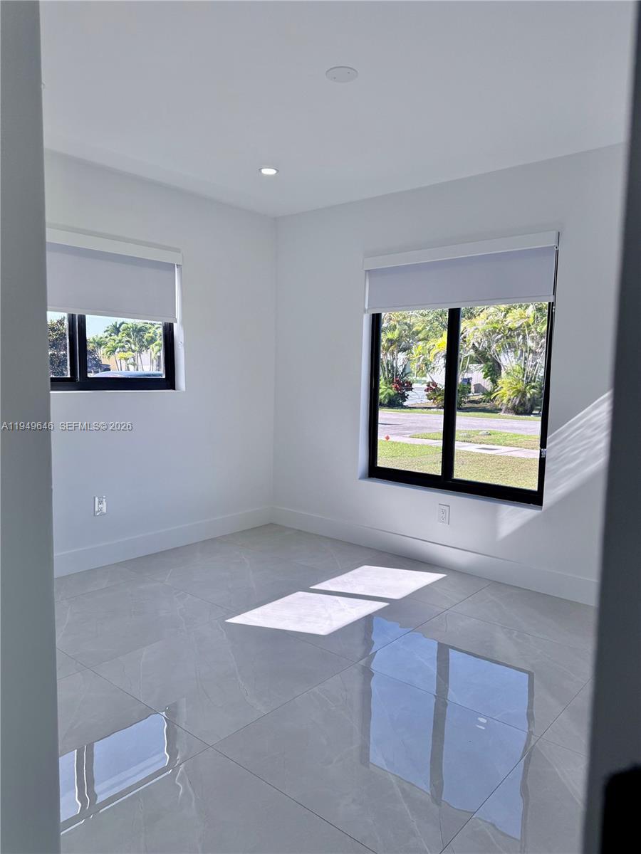 15235 Southwest 108th Court Miami, FL 33157 - Photo 17 of 25 an empty room with windows and ceiling fan