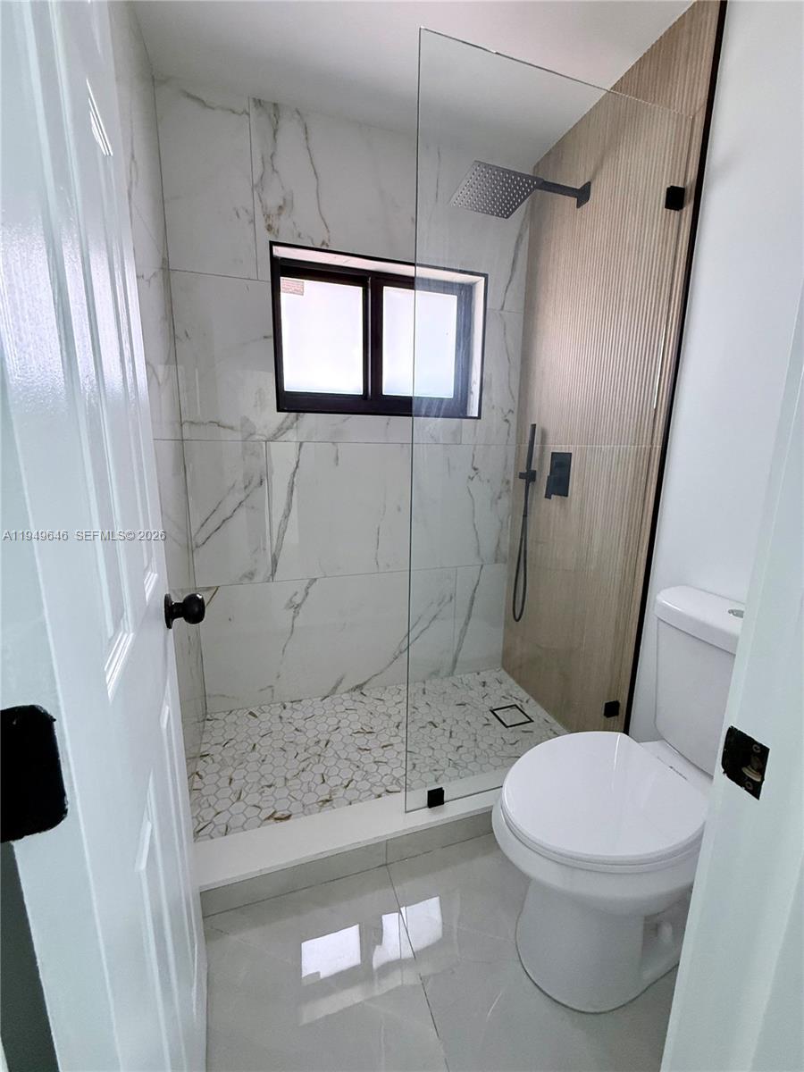 15235 Southwest 108th Court Miami, FL 33157 - Photo 20 of 25 a white toilet sitting next to a bathroom sink and a mirror