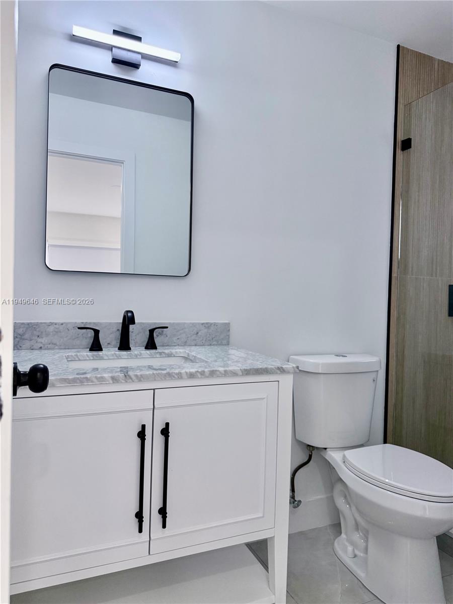 15235 Southwest 108th Court Miami, FL 33157 - Photo 22 of 25 a bathroom with a toilet sink vanity and mirror