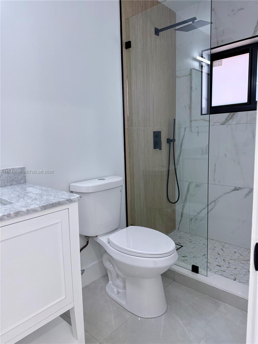 15235 Southwest 108th Court Miami, FL 33157 - Photo 23 of 25 a bathroom with a granite countertop toilet a sink and shower