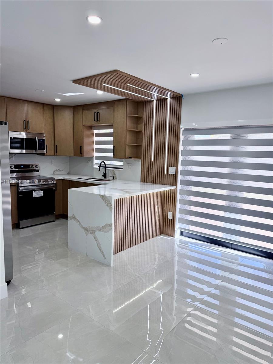 15235 Southwest 108th Court Miami, FL 33157 - Photo 8 of 25 a kitchen with stainless steel appliances kitchen island granite countertop a sink and cabinets