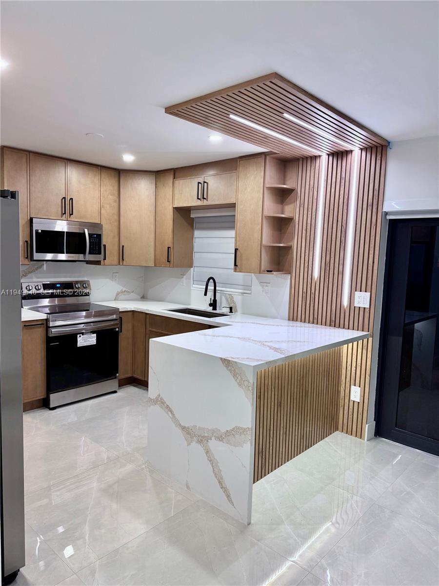 15235 Southwest 108th Court Miami, FL 33157 - Photo 9 of 25 a kitchen with kitchen island a sink stainless steel appliances and cabinets