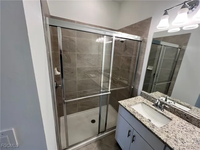 a bathroom with a granite countertop sink toilet and shower
