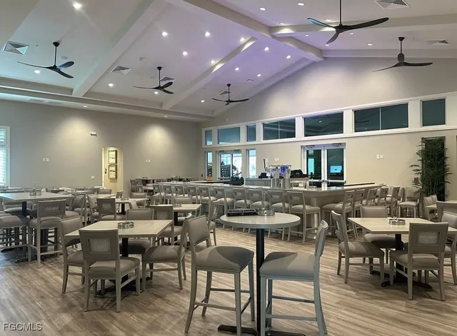 a large dining space with furniture a rug a flat screen tv a rug and a large window