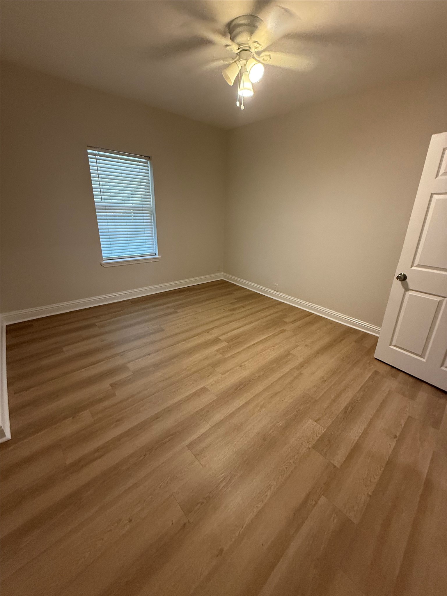 320 Delaware Street Houston, TX 77029 - Photo 6 of 10 an empty room with wooden floor and fan