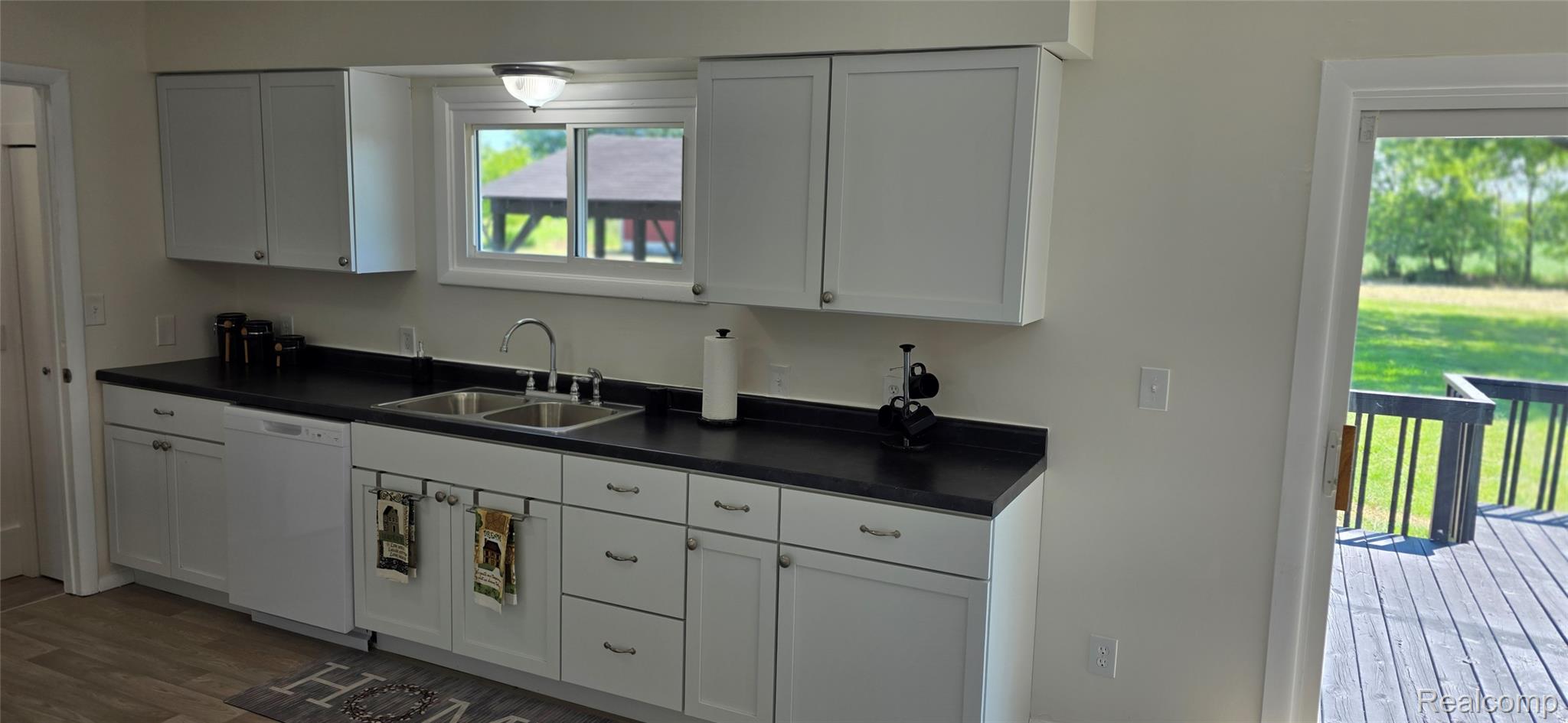 4363 West Dodge Road Clio, MI 48420 - Photo 9 of 52 Kitchen featuring white shaker-style cabinetry, dark countertops, a double basin stainless steel sink, and a built-in dishwasher