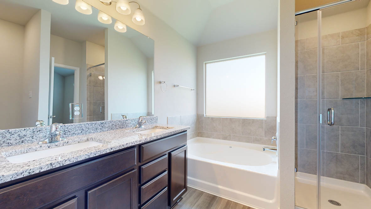 104 Kenzie Street Thorndale, TX 76577 - Photo 18 of 28 a bathroom with a granite countertop bathtub a sink and a large mirror