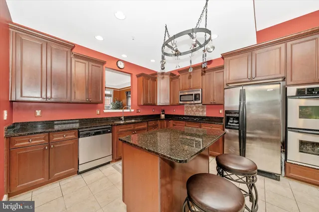 a kitchen with stainless steel appliances granite countertop a sink a stove top oven a counter space and cabinets