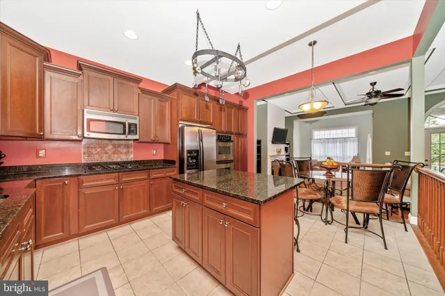 a kitchen with granite countertop a refrigerator stove and microwave