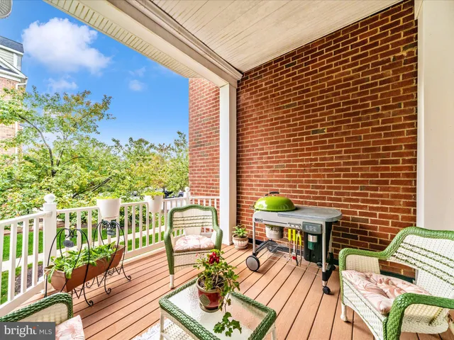 a view of a patio with couches chairs and wooden floor