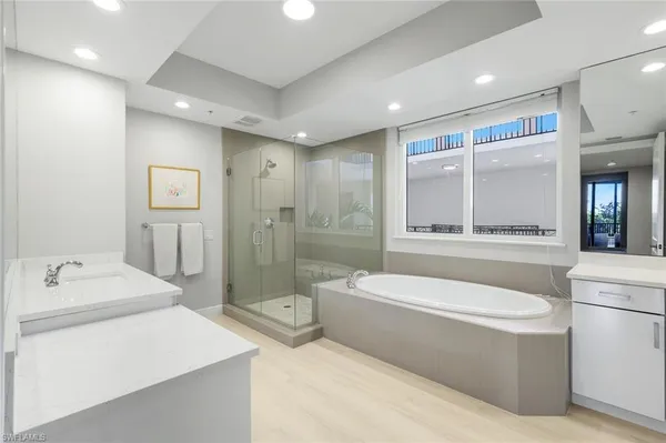 a bathroom with a bathtub a mirror a double vanity sink and
