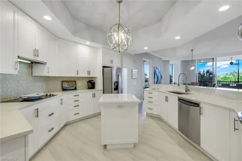 a kitchen with stainless steel appliances granite countertop a sink dishwasher stove refrigerator and cabinets