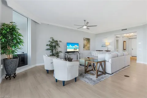a living room with furniture a potted plant and a window